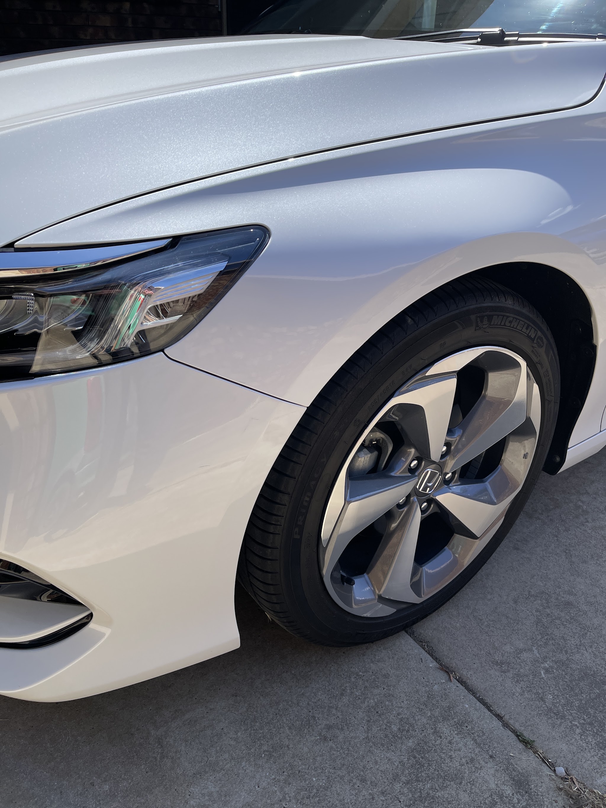 Front quarter panel of a silver Honda after paintless dent repair
