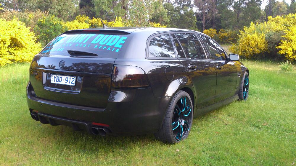The Dint Dude work car, a black wagon with the paintless dent repair decal across the rear window